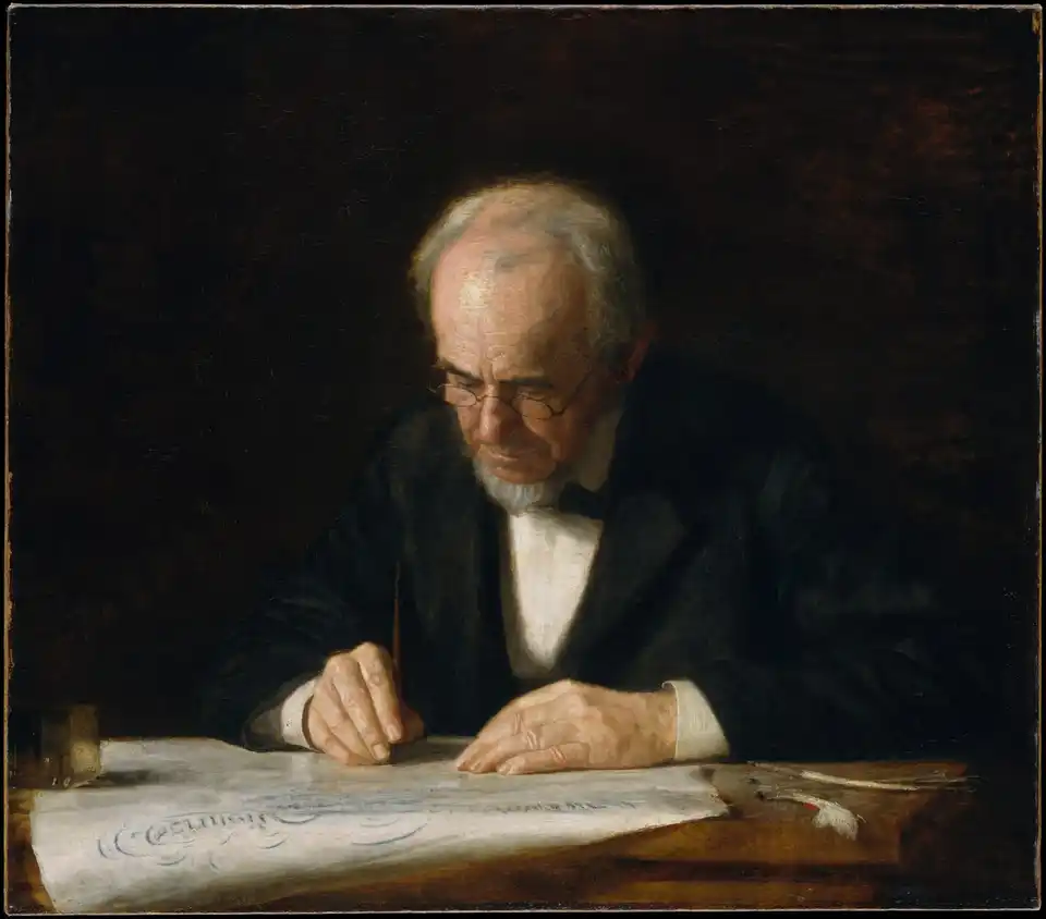An older man wearing spectacles bends over a document at a wooden desk, writing with his right hand and holding the paper with his left.